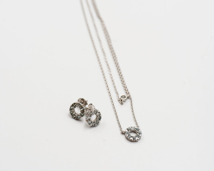 127 Set Chain and Earring Elegant silver round earrings and chain set, featuring a combination round pendant with March blue topaz stones.