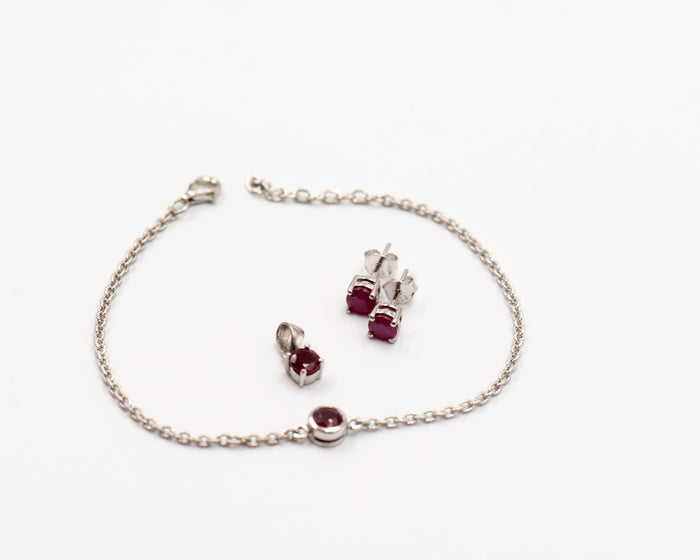 140 Set Elegant silver 3-piece set, featuring round earrings with 50mm January garnet stones, a matching pendant, and a bracelet with garnet stones.