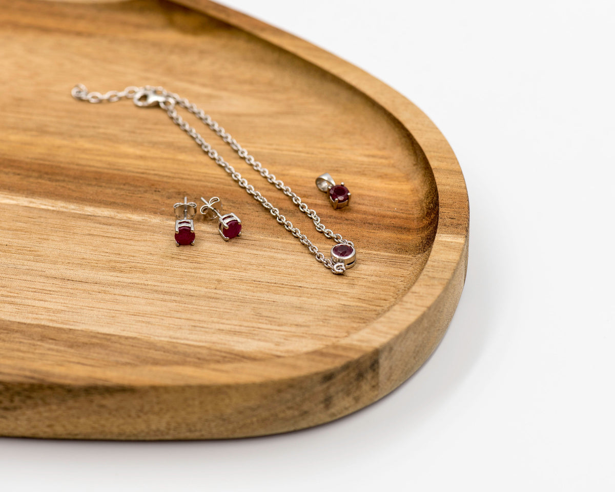 146 Elegant silver 3-piece set, featuring round earrings with 50mm July ruby stones, a matching pendant, and a bracelet with ruby stones.