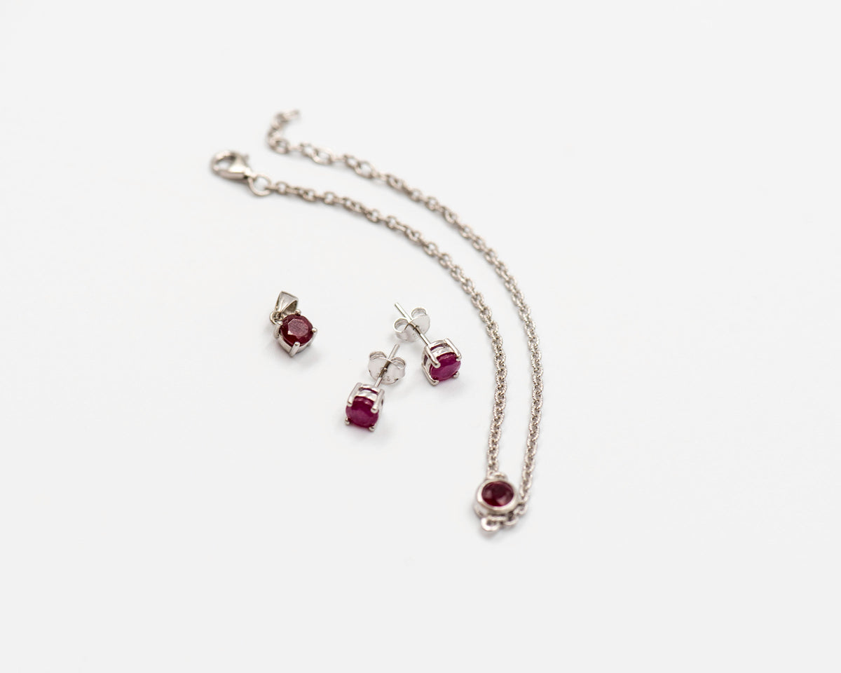 146 Elegant silver 3-piece set, featuring round earrings with 50mm July ruby stones, a matching pendant, and a bracelet with ruby stones.