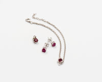 146 Elegant silver 3-piece set, featuring round earrings with 50mm July ruby stones, a matching pendant, and a bracelet with ruby stones.