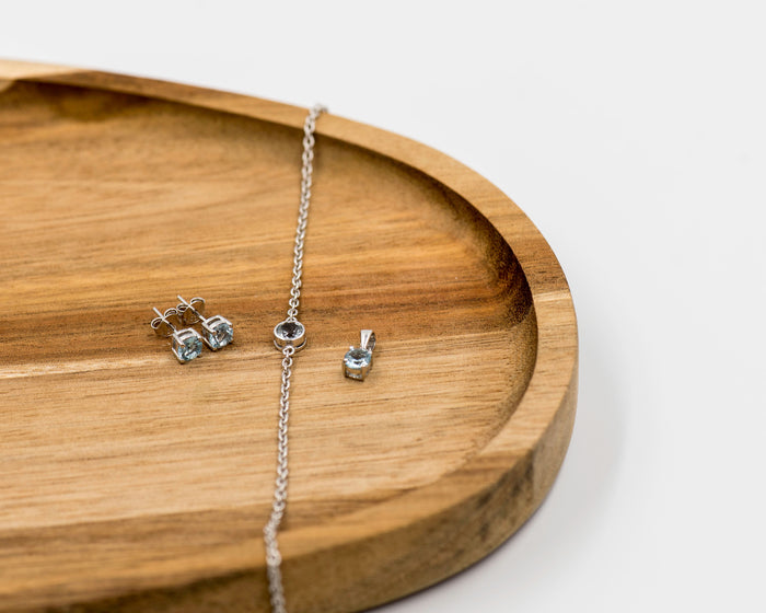 142 Elegant silver 3-piece set, featuring round earrings with 50mm March blue topaz stones, a matching pendant, and a bracelet with blue topaz stones.