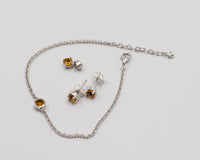 150 Elegant silver 3-piece set, featuring round earrings with 50mm November citrine stones, a matching pendant, and a bracelet with citrine stones.