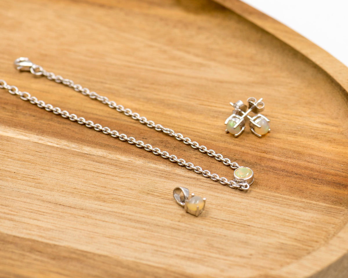 149 Elegant silver 3-piece set, featuring round earrings with 50mm October opal stones, a matching pendant, and a bracelet with opal stones.