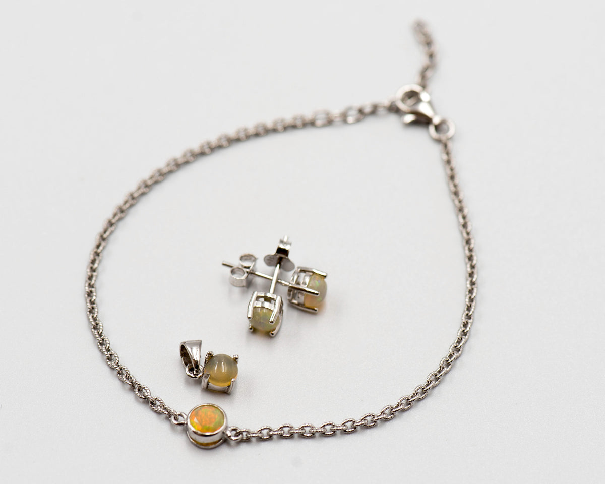 149 Elegant silver 3-piece set, featuring round earrings with 50mm October opal stones, a matching pendant, and a bracelet with opal stones.