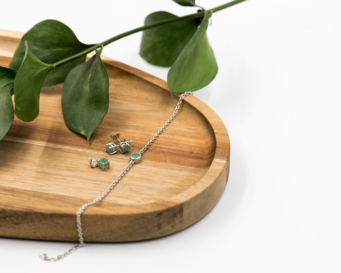 144 Elegant silver 3-piece set, featuring round earrings with 50mm May emerald stones, a matching pendant, and a bracelet with emerald stones.