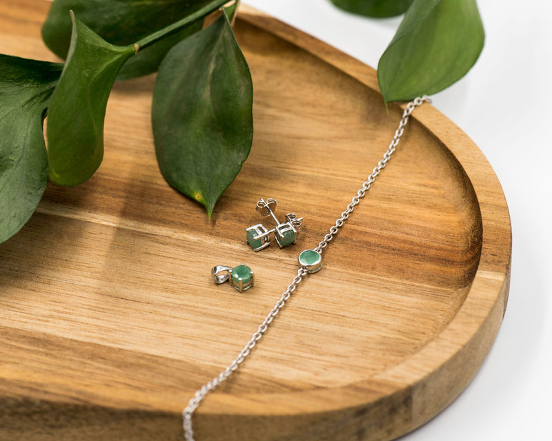 144 Elegant silver 3-piece set, featuring round earrings with 50mm May emerald stones, a matching pendant, and a bracelet with emerald stones.