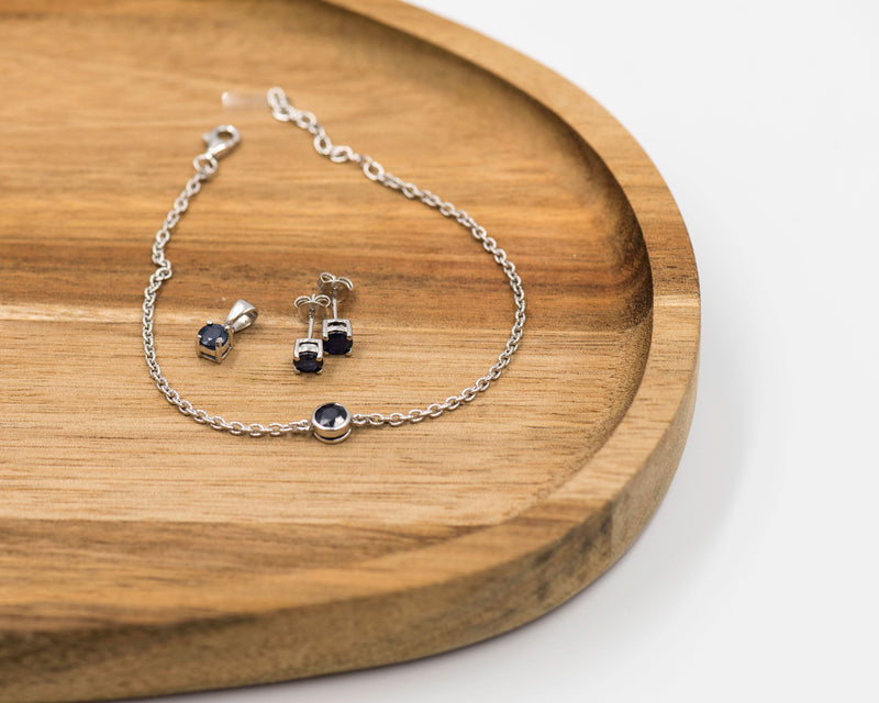 148 "Elegant silver 3-piece set, featuring round earrings with 50mm September sapphire stones, a matching pendant, and a bracelet with sapphire stones.